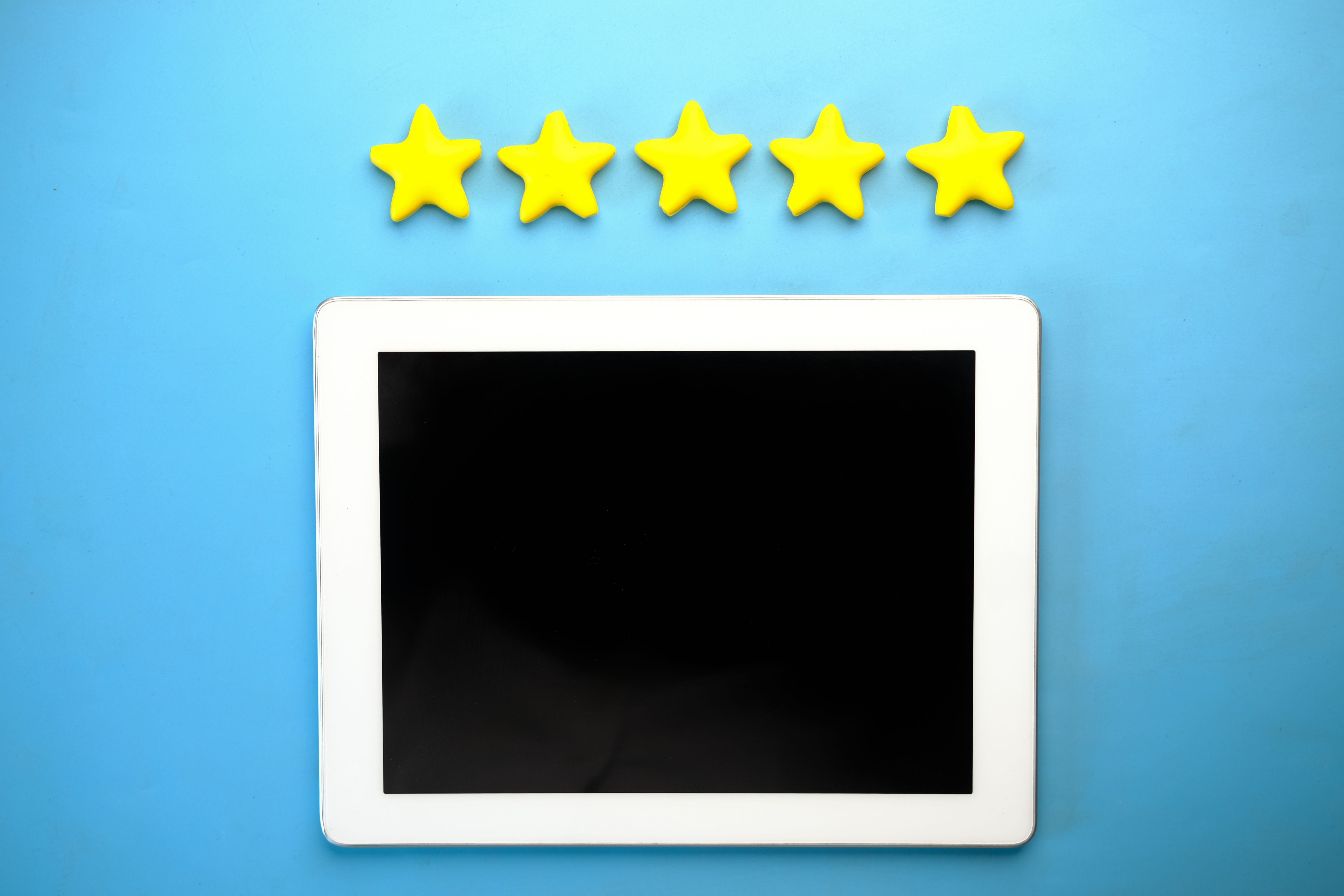 Tablet displaying five yellow rating stars representing positive customer reviews for a local business