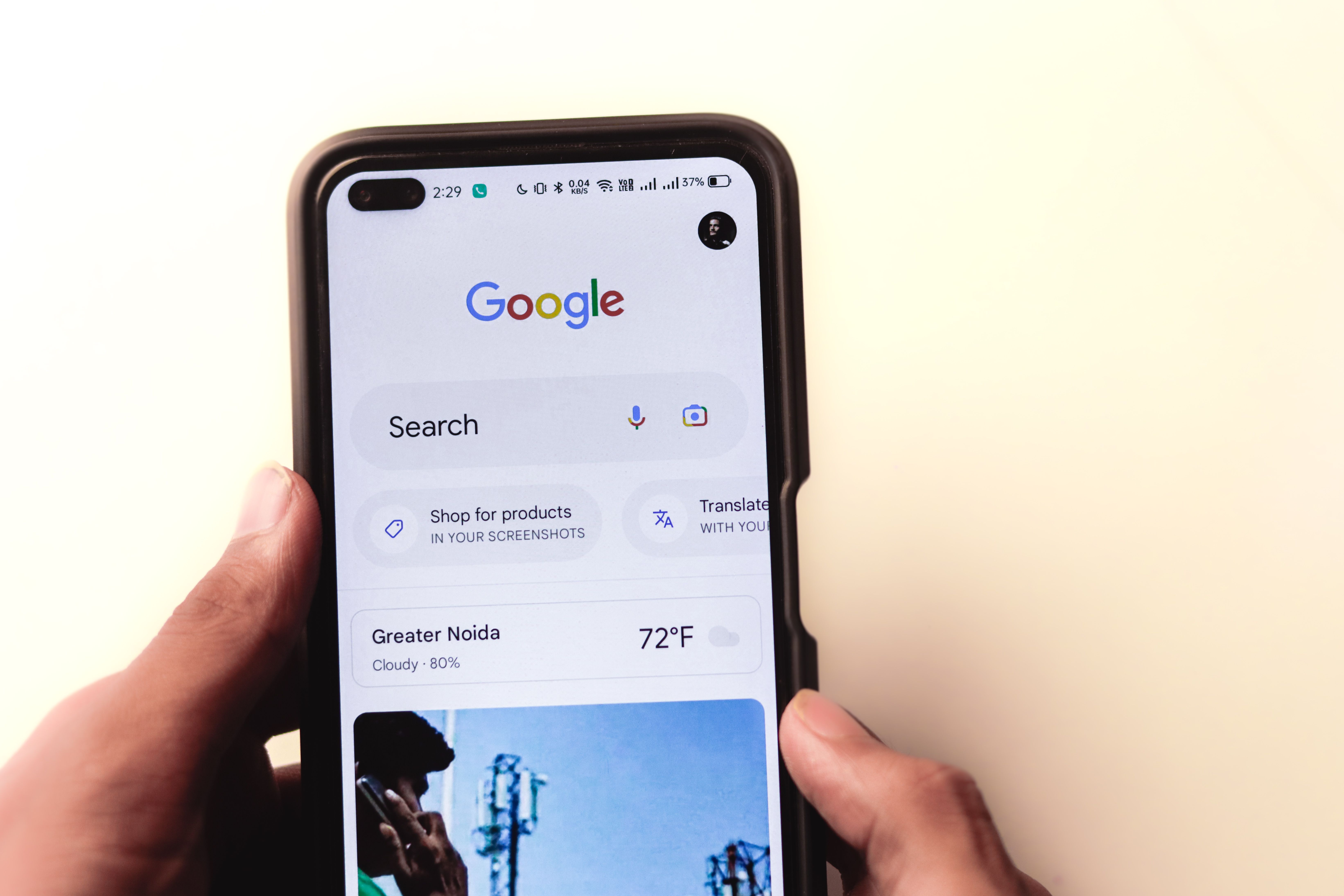 Hand holding a smartphone displaying a Google search page used to find local services