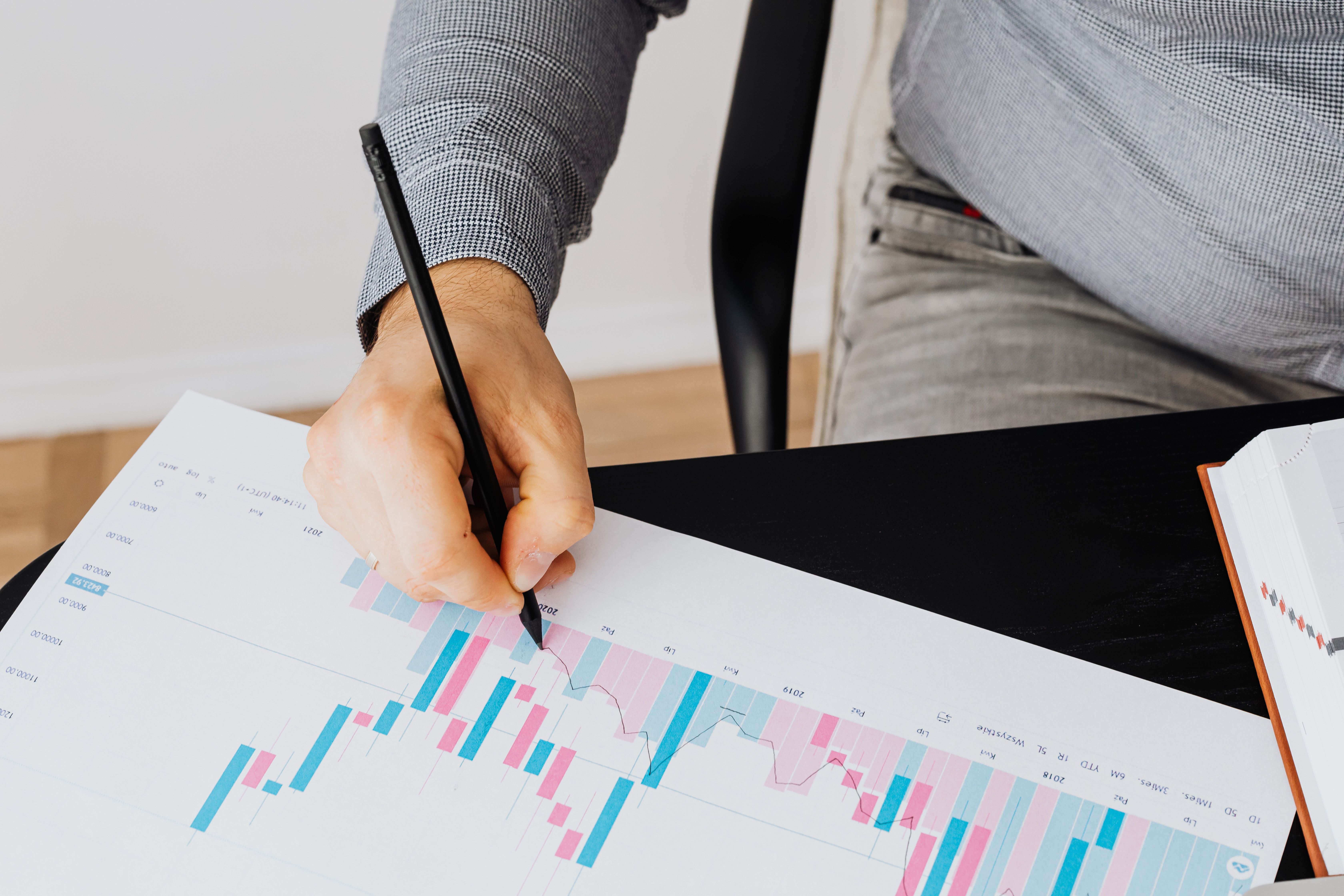 Professional examining a financial growth graph with a pen during business analysis.